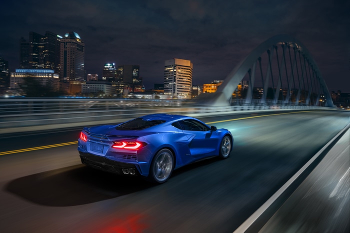 Blue Chevrolet Corvette E-Ray driving on a bridge at night
