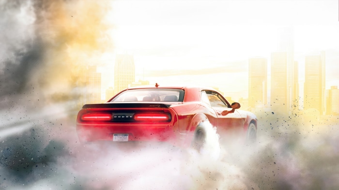 Red Dodge Challenger drifting in smoke