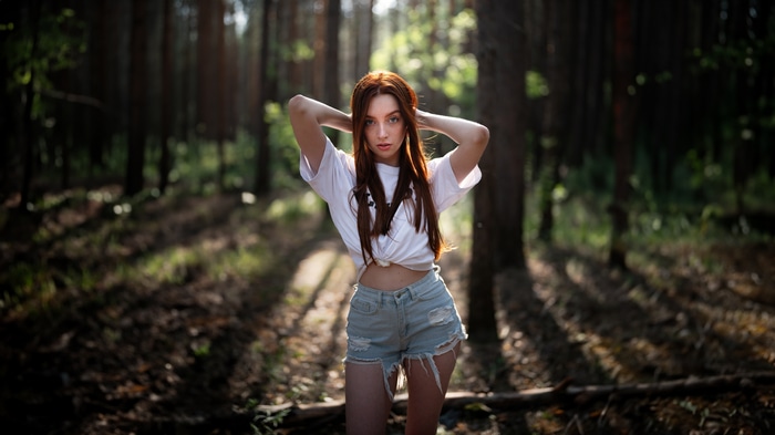 Redhead girl in denim shorts in a forest
