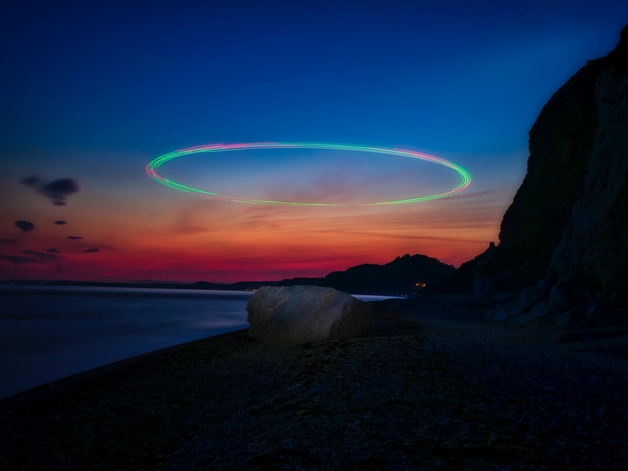 Light painting oval over a beach at sunset 4K