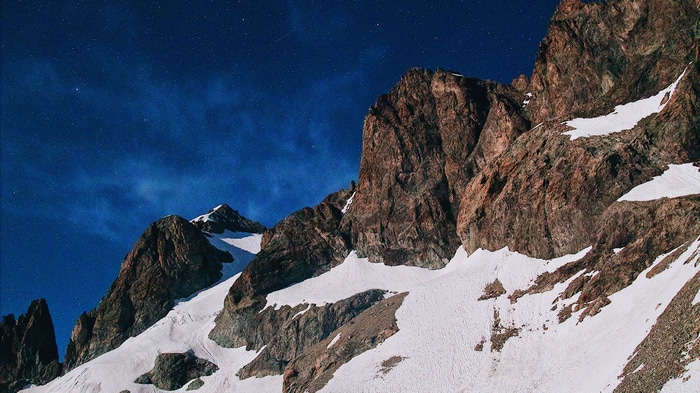 Snowy mountains under a starry night sky 4K