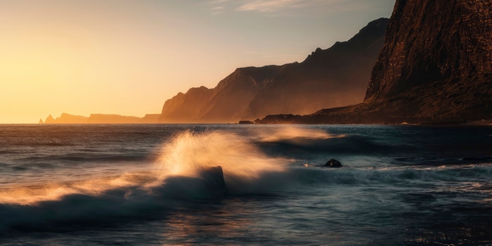 Ocean waves crashing on rocks at sunrise, 4K