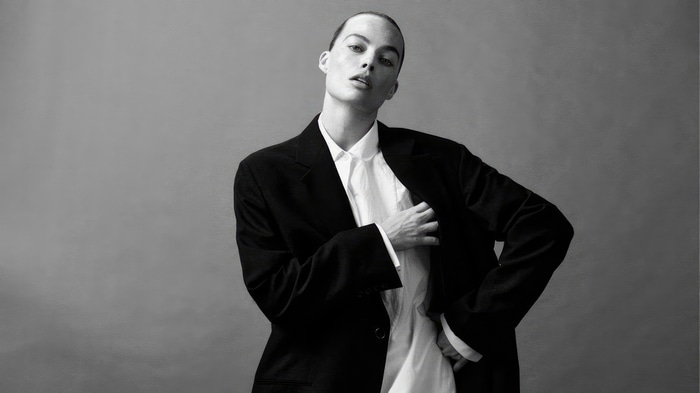 Margot Robbie in a black suit and white shirt