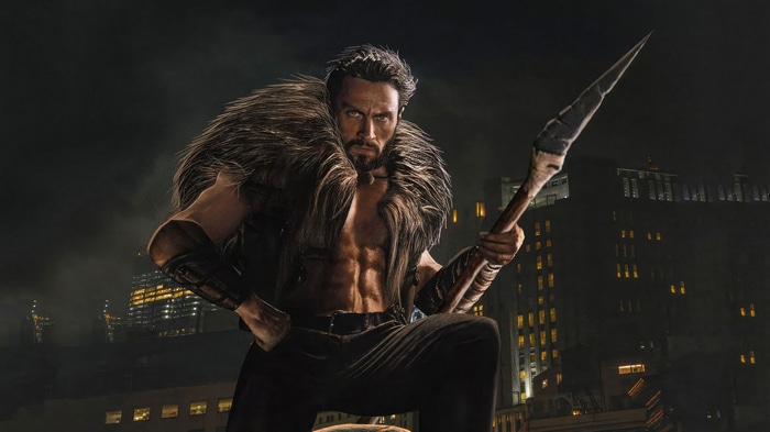 Kraven the Hunter holding a spear in front of city buildings