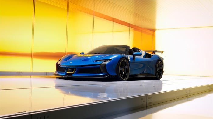 Blue Ferrari SF90 XX Spider in a modern showroom