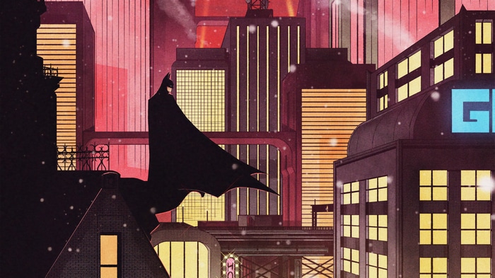 Batman standing on a rooftop in a snowy city