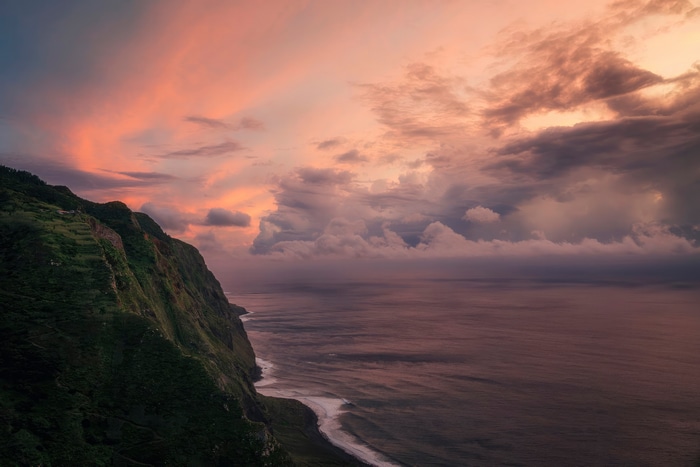 Dramatic sunset over a rugged coastline with ocean waves