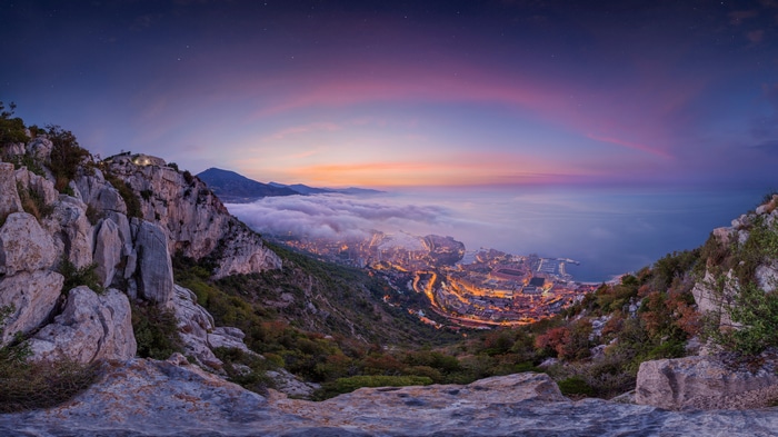Monaco cityscape at dusk with clouds and mountains