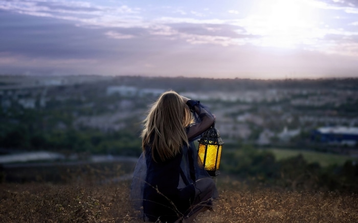 Girl with lantern at sunset