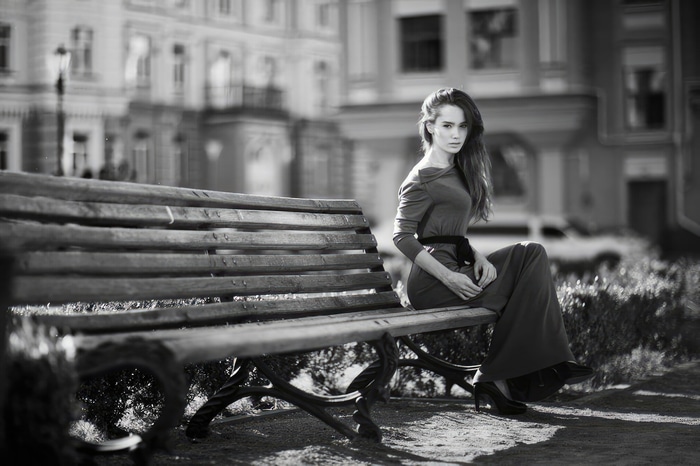 Monochrome portrait of a model in a dress on a bench