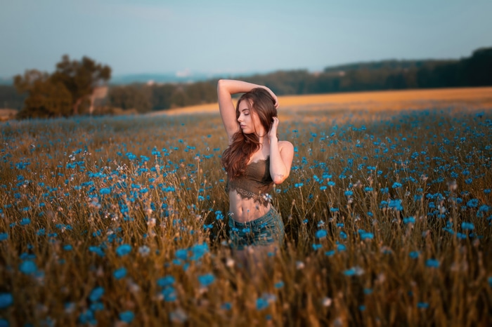 Model in a field of blue flowers 4K