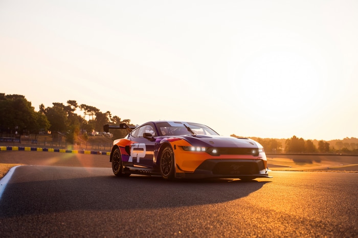 Ford Mustang GT3 race car on a track at sunset