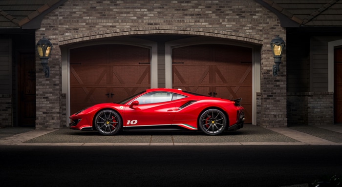 Red Ferrari 488 parked in front of a garage