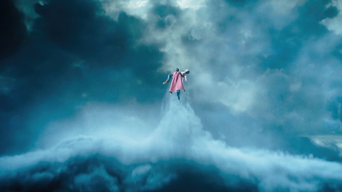 Supergirl flying through stormy clouds