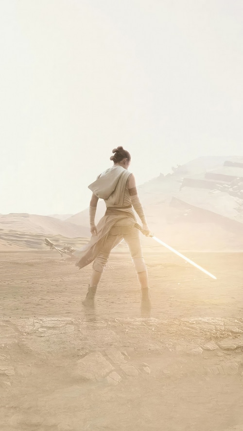 Rey with a lightsaber in Star Wars desert