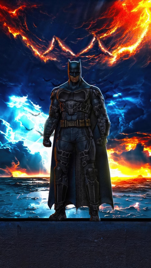 Batman standing against a fiery sky