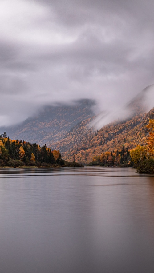Autumn forest and mountains reflected in a lake