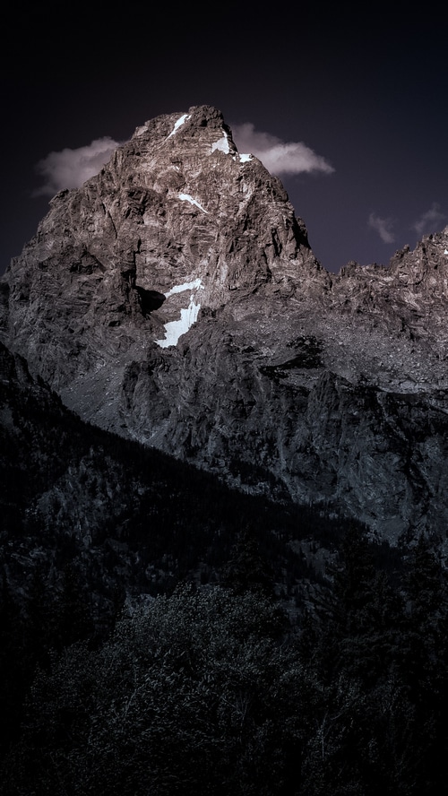Rocky mountain peak with snow and clouds