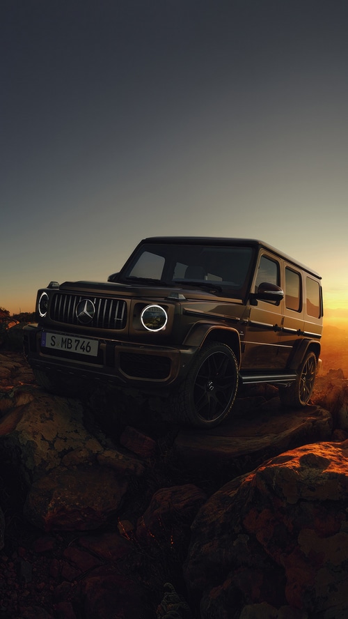 Mercedes-Benz G-Class SUV on rocky terrain at sunset