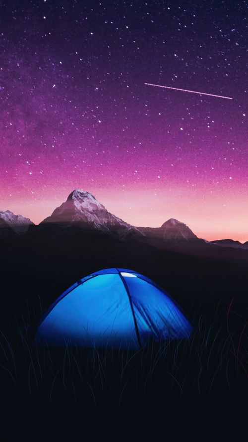 Tent under starry sky with mountains
