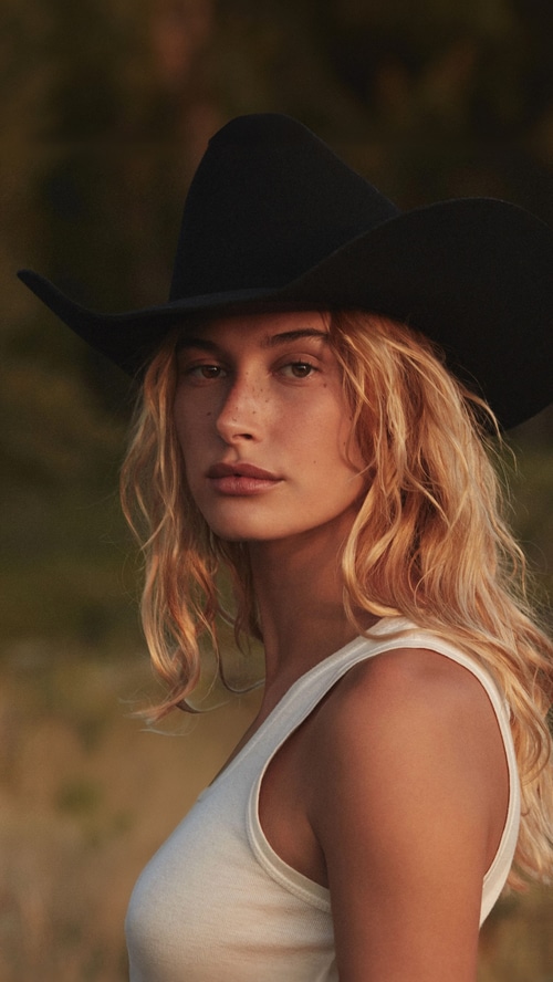 Hailey Bieber wearing a cowboy hat and tank top