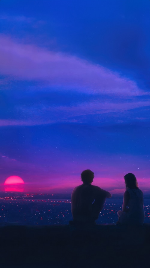 Couple watching a pink sunset over a city