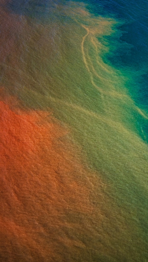 Aerial view of ocean currents with sediment