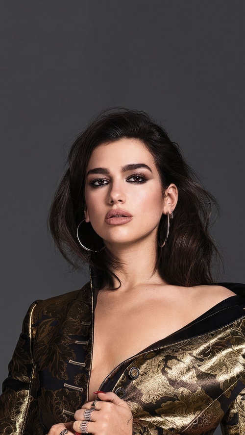 Dua Lipa in a gold and black jacket