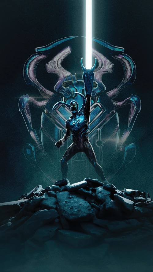Blue Beetle stands on rocks with a large scarab behind him