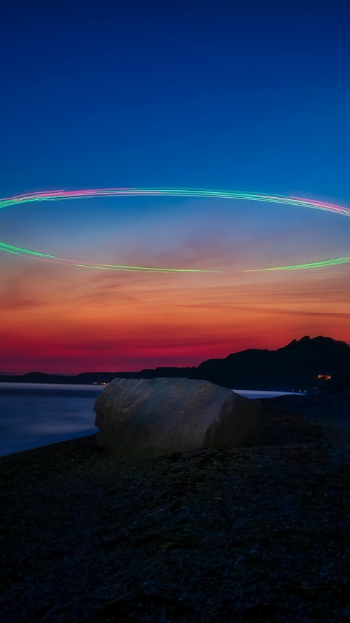 Sunset over the ocean with light trails
