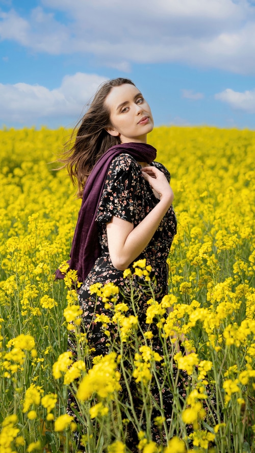 Woman in a floral dress in a yellow flower field