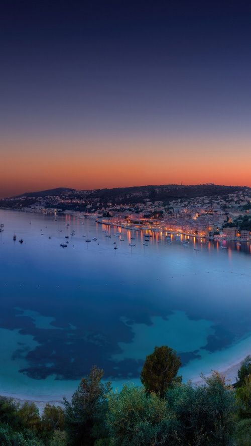 Coastal town at sunset with boats in the bay