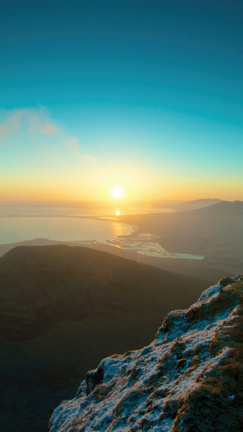 Sunrise over a bay from a mountain peak