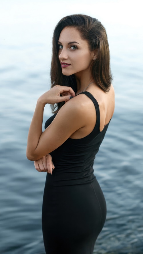 Woman in black dress by the water