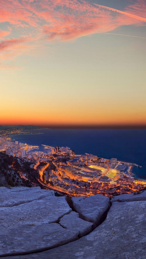 Monaco cityscape at sunset from a rocky viewpoint