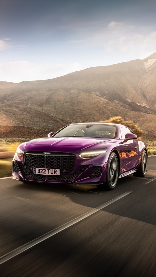 Purple Bentley Batur driving on a mountain road