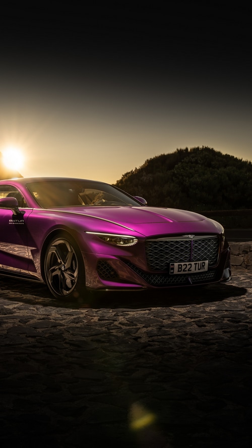 Bentley Batur parked on cobblestone road at sunset