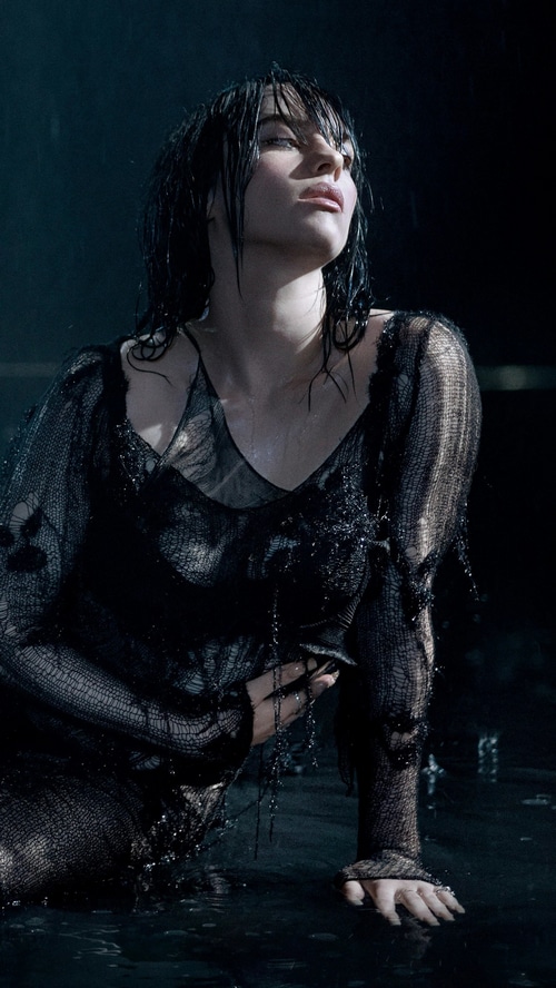 Billie Eilish in a black torn dress in the rain