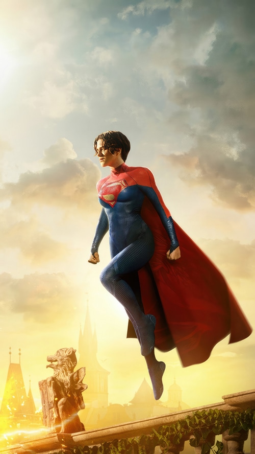 Supergirl flying over a city at sunset