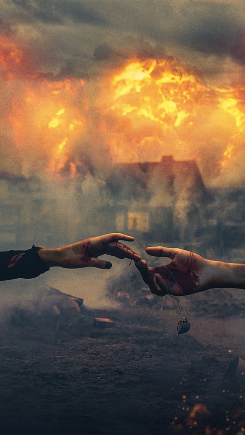 Couple reaching for each other amidst destruction