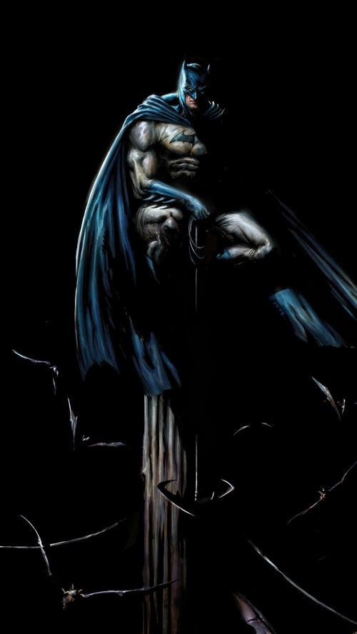 Batman perched on a wooden post with bats flying