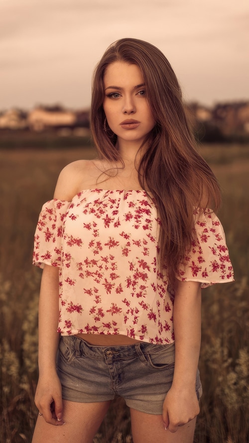Model in floral off-the-shoulder top and denim shorts outdoors