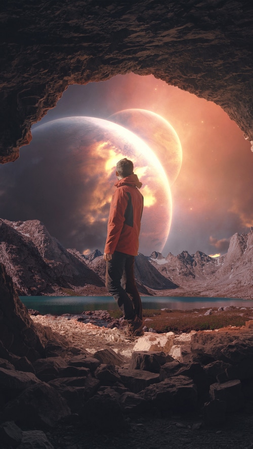 Man looking at alien planets from a cave