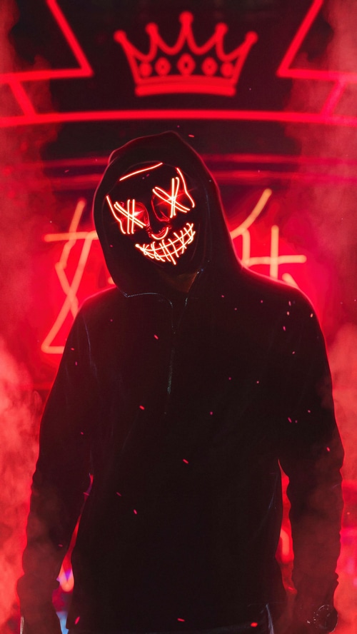 Person in a hoodie wearing a glowing mask