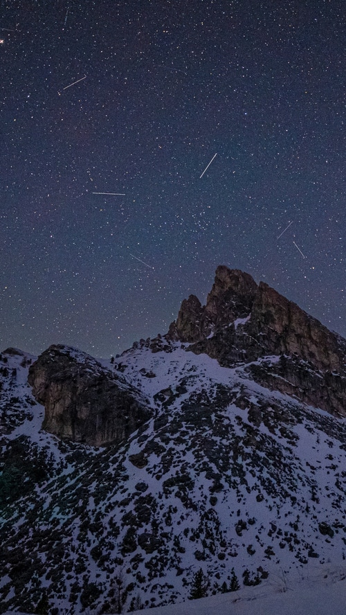 Starry night sky over snow-covered mountains