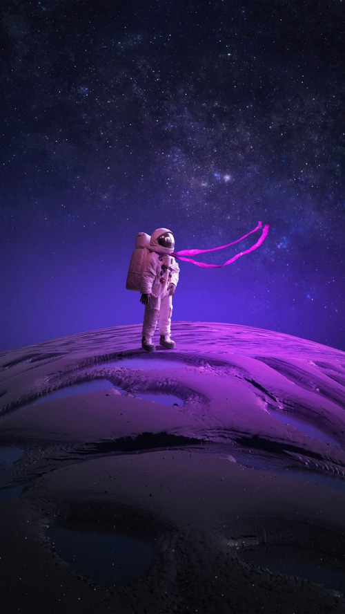 Astronaut on a purple planet under a starry sky