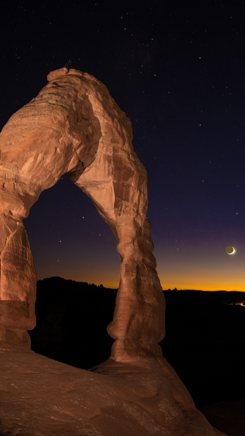 Delicate Arch at night with stars and moon