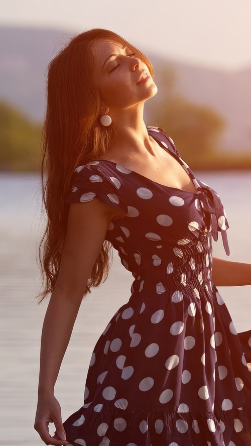 Woman in polka dot dress by the water