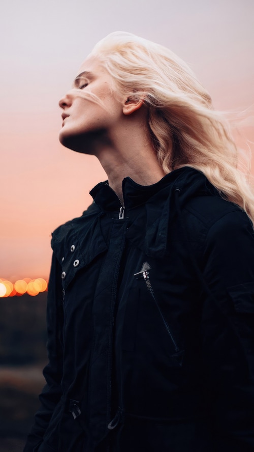 Woman with blonde hair wearing a black jacket