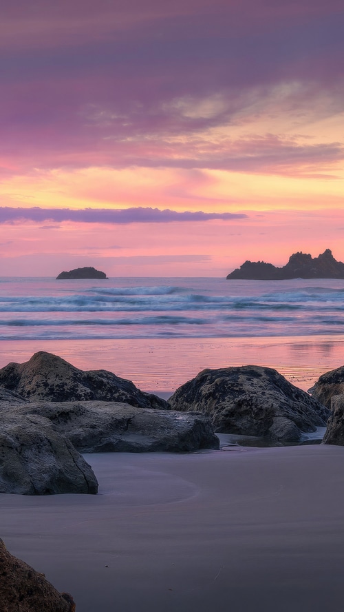 Beach at dawn with pink and purple clouds